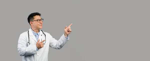 Wesoły Dojrzały Chiński Terapeuta Białym Płaszczu Okularach Wskazujących Palcem Przestrzeń — Zdjęcie stockowe