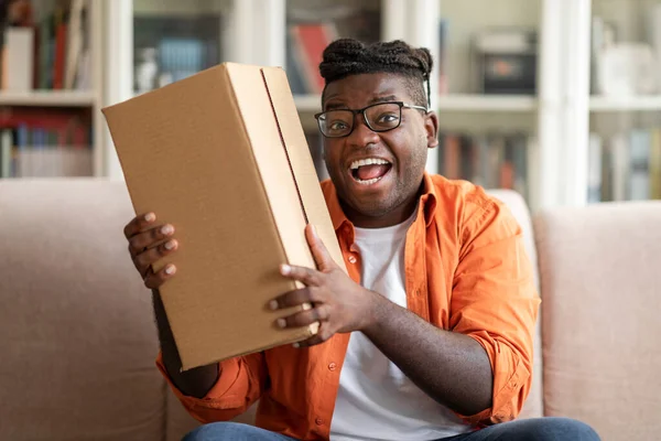 興奮太りすぎ黒男性顧客を受け取る良い小包段ボール箱で自宅満足偉大な購入 幸せな黒男性消費者保持パッケージによって喜び郵便配送 — ストック写真