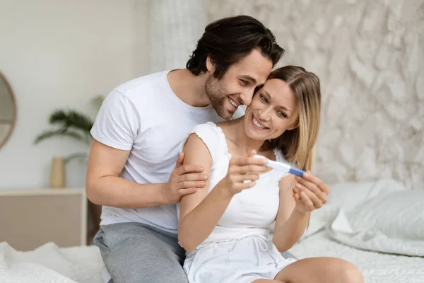 Portrait Happy Caucasian Couple Holding Positive Pregnancy Test Sitting Bed — Stock Photo, Image