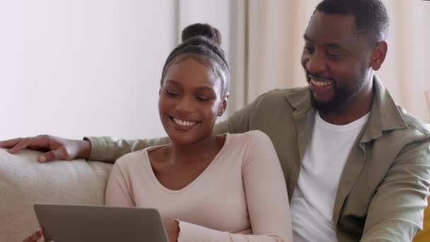 一緒に計画してる 若い幸せなアフリカ系アメリカ人のカップルは レンタルアパートやオンラインショッピングを選択し 一緒に選択を議論し ショットを追跡し スローモーション フリースペース — ストック動画