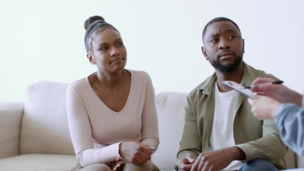 家族の支援と精神的外傷 若い感情的なアフリカ系アメリカ人の女性はセラピストと泣き 彼女の思いやりのある夫は彼女をサポートし 撮影を追跡し スローモーション フリースペース — ストック動画