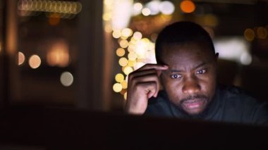 İşçilik konsepti. Genç konsantre olmuş Afro-Amerikan erkek yöneticisinin portresi. Geç saatlere kadar evde çalışıyor. Laptoptan okuma projesi, izleme çekimi, yavaş çekim, serbest alan.