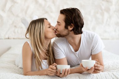 Kafkasyalı çifti öpüşürken otel yatağında sabah kahvesi içerken, elinde fincanlar tutarken, kahvaltı yaparken ve birlikte vakit geçirirken sevmek.