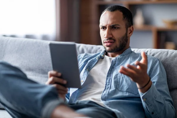 Stressed Young Black Man Looking Digital Tablet Screen Frowning While — Stock Photo, Image