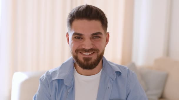 积极的生活方式 近照年轻英俊的中东男子对着镜头微笑 坐在家里 慢动作 — 图库视频影像