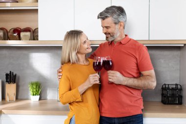 Romantik, orta yaşlı karı koca mutfak masasının yanında durur, sarılır, evde şarap içer, birlikte vakit geçirir, fotokopi çekerler. Aşk, aile, sevgi, ilişkiler