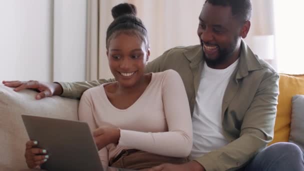 年轻快乐的非洲裔美国夫妇在家里一起上网浏览数字平板电脑 讨论内容 周末在家里休息 跟踪镜头 慢动作 自由自在的空间 — 图库视频影像