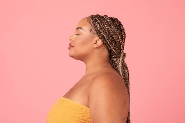 Doğal güzellik. Kusursuz derisi olan, pembe arka plan üzerinde gözleri kapalı, havluya sarılı, siyah, güzel bir kadının profil fotoğrafı.