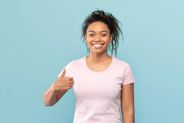 快乐的非洲裔美国女人展示出了大拇指的姿势 推荐或认可了一些东西 摆出一副蓝色工作室的样子 最佳选择概念 — 图库照片