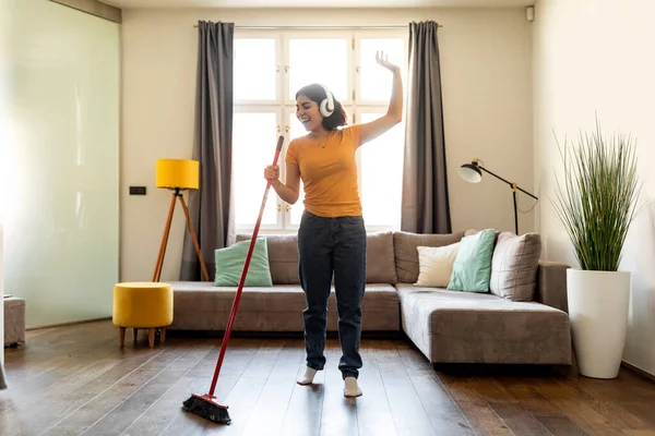Alegre Joven Árabe Mujer Auriculares Divertirse Mientras Hacer Limpieza Casa —  Fotos de Stock