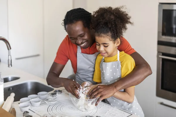 Caring African American Dad Teaching His Daughter How To Make Dough While They Baking Together At Home, Young Black Father And Preteen Female Child Preparing Pastry In Kitchen, Free Space