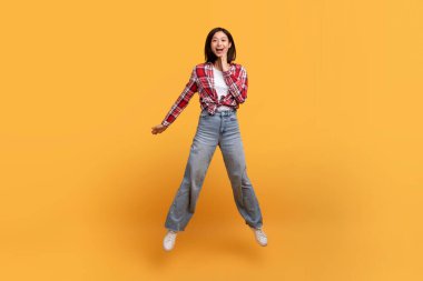 Vay canına. Şaşırmış Asyalı kadının tüm vücut uzunluğundaki görüntüleri kameraya bakıyor. Haberler ya da sunumlar karşısında şoka uğruyor. Sarı stüdyo arka planında izole edilmiş.