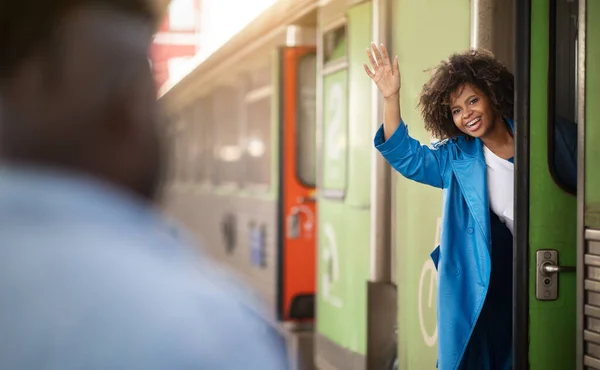 Счастливая Черная Женщина Стоит Дверях Поезда Машет Рукой Своему Парню — стоковое фото
