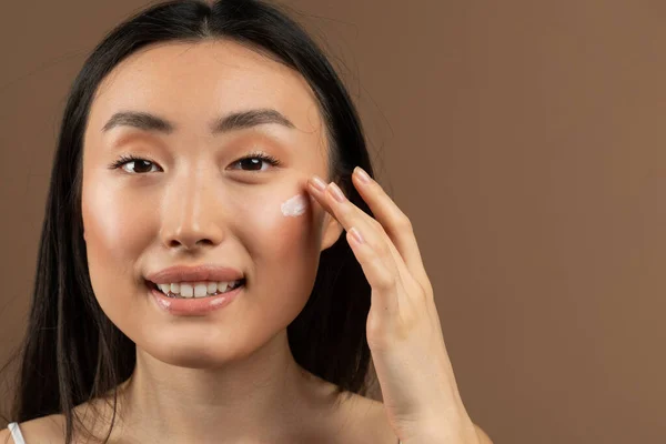 Retrato Señora Asiática Aplicando Crema Facial Antienvejecimiento Hidratante Posando Sobre — Foto de Stock