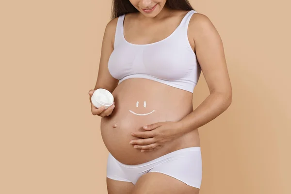 Беременная Женщина Нижнем Белье Улыбкой Лице Крема Животе Стоя Изоляции — стоковое фото