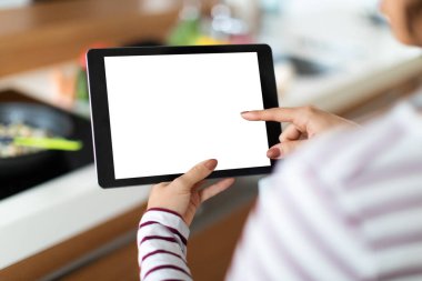 Tanımlanamayan bir kadının evde lezzetli sağlıklı yiyecekler pişirdiği, beyaz ekranlı dijital tablet kullandığı, güzel yemek uygulamalarını kontrol ettiği, ped, fotokopi, maket,