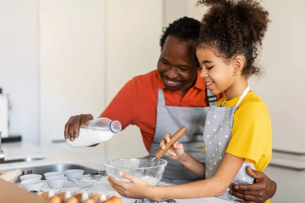 Happy African American Dad And His Preteen Daughter Baking Pastry In Kitchen Together, Smiling Black Father And Female Child Having Fun While Making Dough For Muffins At Home, Free Space