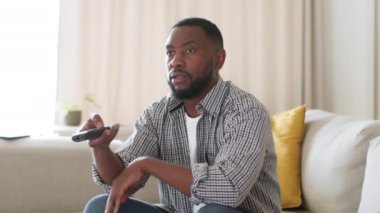 Televizyonda ilginç bir şey yok. Sıkıcı genç Afrikalı Amerikalı adam evde uzaktan kumandayla oturuyor ve yayın yapan kanalları değiştiriyor, çekim takibi, yavaş çekim, serbest alan.