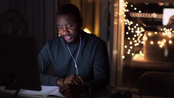 Young African American Man Student Earphones Studying Late Evening Home — Vídeos de Stock