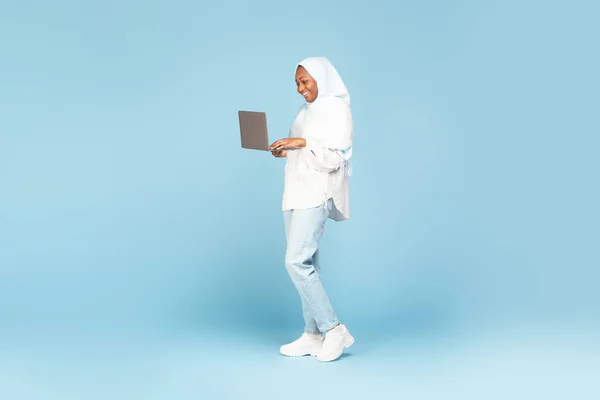 Mavi Stüdyo Arka Planında Dizüstü Bilgisayarla Poz Veren Tesettürlü Afro — Stok fotoğraf