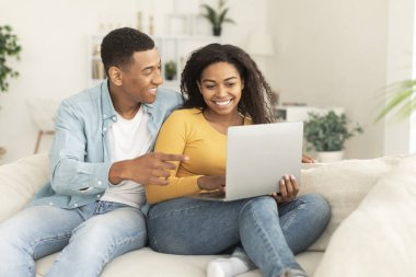 Bin yıllık Afro-Amerikan kadınlarının erkeklere dizüstü bilgisayar göstermesine sevindim. Oturma odasında yeni bir uygulama ve video önerdiler. İletişim, reklam ve sunum için ev, teknoloji ve sosyal ağlar çevrimiçi çağrı