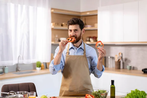 Happy Millennial Caucasian Male Apron Prepares Food Bites Piece Pepper —  Fotos de Stock