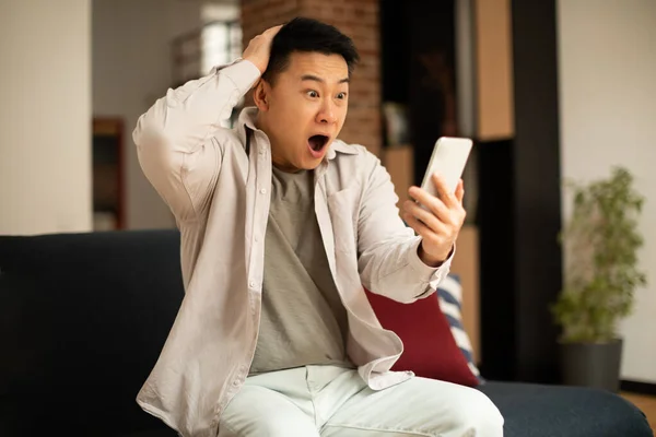 Shocked Mature Asian Man Reading Bad Message Smartphone While Sitting — Stock Photo, Image