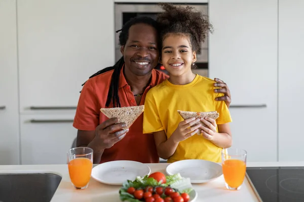 Portrait Happy Black Father Cute Preteen Daughter Eating Sandwiches Kitchen —  Fotos de Stock