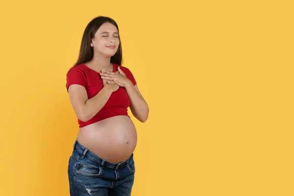 Thankful Pregnant Woman Keeping Hands Chest While Standing Isolated Yellow — Stock Photo, Image