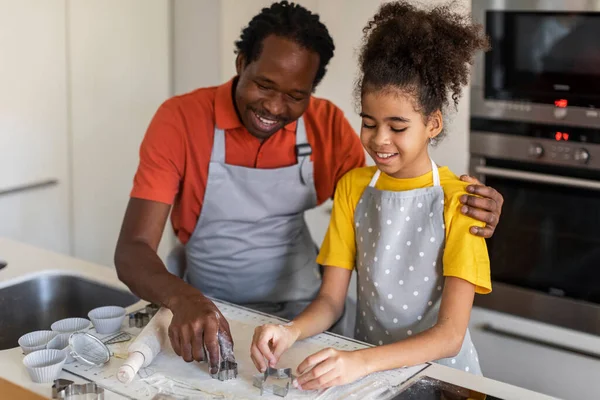 Happy Black Dad And Daughter Cutting Out Different Cookie Shapes Of Dough While Baking Together In Kitchen, Father And Preteen Female Child Using Stainless Steel Molds, Enjoying Cooking At Home