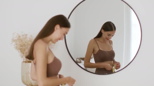 Νεαρή Όμορφη Γυναίκα Που Κοιτάζει Τον Καθρέφτη Μετρώντας Μέση Της — Αρχείο Βίντεο
