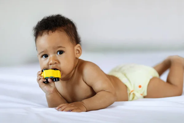Teething Concept Adorable Little Black Baby Biting Toy While Lying — Photo