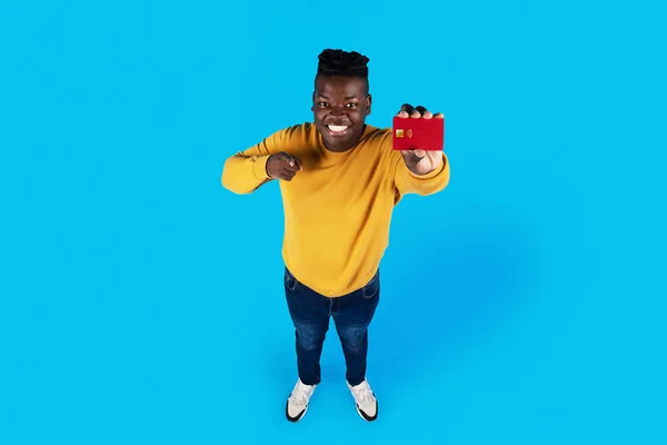 Cheerful Black Guy Holding Credit Card His Hand Pointing Camera —  Fotos de Stock