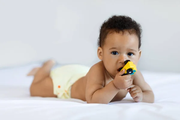Cute African American Infant Baby Lying Bed Biting Toy Portrait —  Fotos de Stock