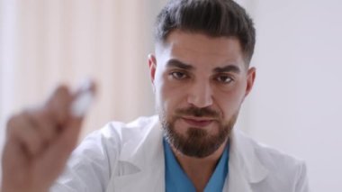 Medical examination. Patient pov shot of professional middle eastern man therapist checking sore throat with spatel, close up, slow motion