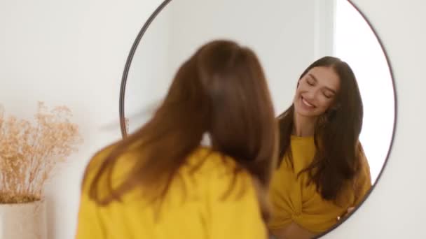 自我激励的时刻 照片上的年轻无忧无虑的女士在家里跳舞 对着镜子的倒影微笑 跟踪镜头 慢动作 自由自在的空间 — 图库视频影像