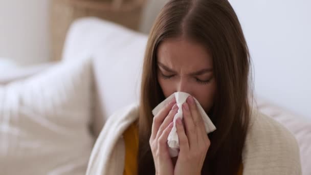 季节性流感和感冒 年轻的病人把她的鼻子吹进纸巾里 鼻腔感染 坐在家里 动作缓慢 空间空虚 这些都是她的近照 — 图库视频影像