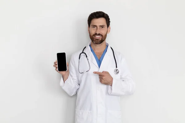 Medical Insurance Handsome Male Doctor Wearing Uniform Pointing Blank Smartphone — Stok fotoğraf