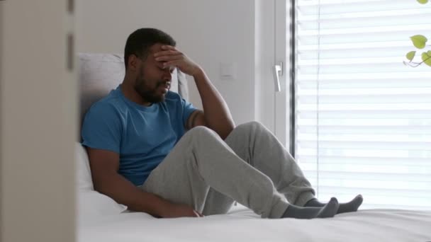季節性うつ病の概念 若いアフリカ系アメリカ人の男性がストレスや無関心さに苦しみ 窓の近くに座って問題を考え ショットを追跡し 動きを遅くし 空のスペース — ストック動画
