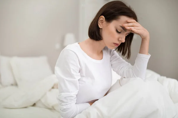 Young Sick Brunette Woman Headache Sitting Bed Closed Eyes Touching — Fotografia de Stock