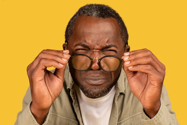 Concentrated African American Middle Aged Man Squinting Eyes Takes Glasses — Stockfoto