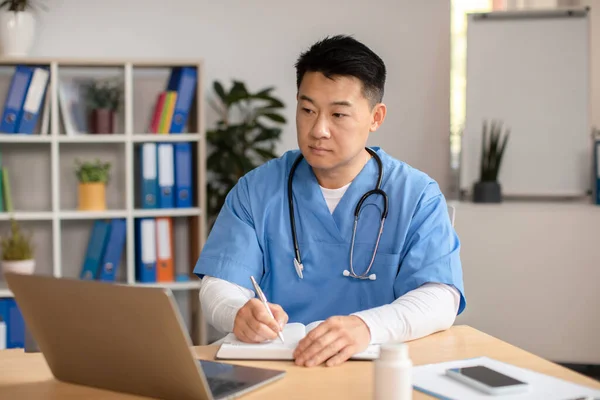 Serious Middle Aged Korean Doctor Uniform Stethoscope Looks Computer Makes — Stock Photo, Image