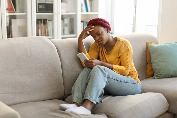 Breakup Depression Concept Upset Young Black Woman Sitting Sofa Cellphone —  Fotos de Stock