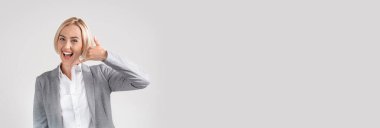 Contact Us. Wide Horizontal Banner With Smiling Businesswoman Showing Phone Call Gesture While Posing Over Light Grey Studio Background, Extended Shot With Friendly Female Entrepreneur, Copy Space