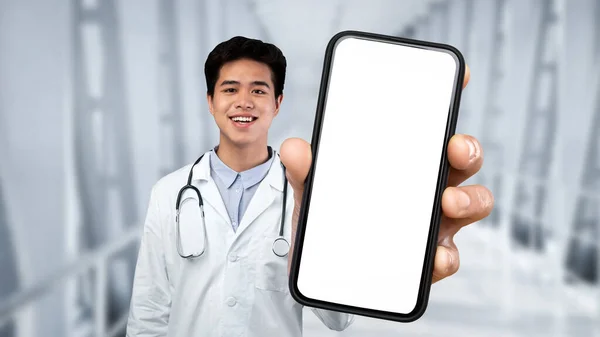 Smiling Asian Male Doctor Wearing Uniform Showing Big Smartphone Blank — Stok fotoğraf