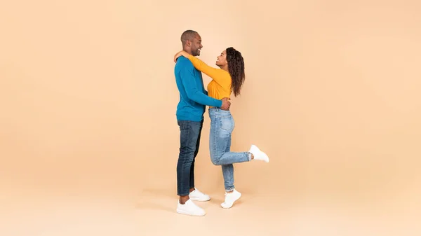 恋のカップル アフリカ系アメリカ人の配偶者は 桃のスタジオの背景 パノラマ サイドビュー 完全な長さのショットの上に立って抱きつく 中年男性と若い女性を受け入れます — ストック写真