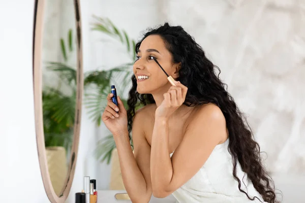 Cheerful Arabic Millennial Curly Lady Towel Apply Mascara Eyelashes Looking — Stock Photo, Image