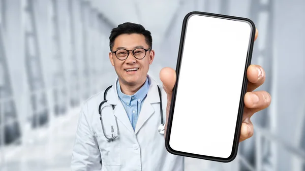 Happy Asian Doctor Man Holding Big Blank Smartphone White Screen — Stok fotoğraf