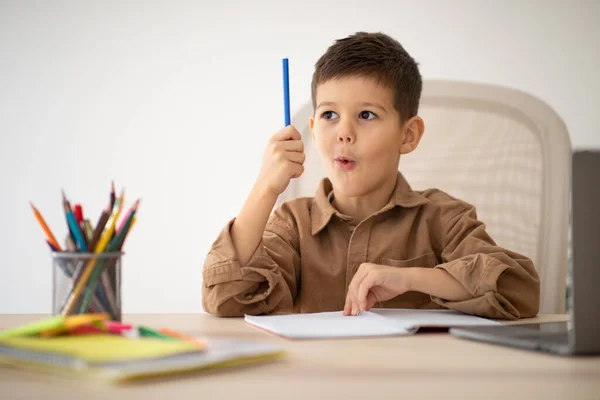 Cheerful Cute Little Boy Sits Table Studies Looks Pencil Got — Stock fotografie