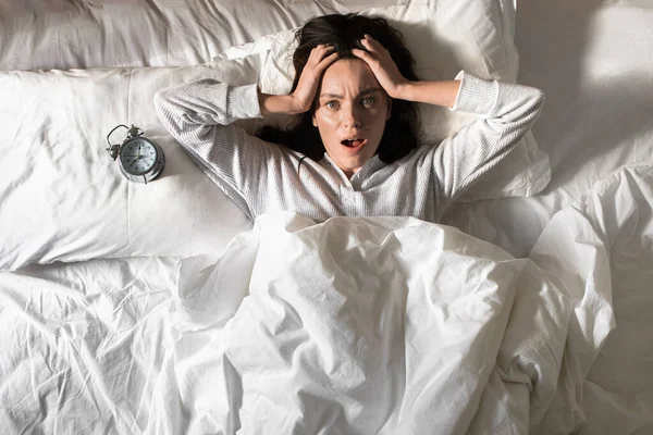 Shocked Young European Woman Pajamas Woke Holding Her Head Lies — Zdjęcie stockowe